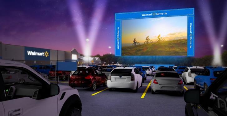 A screen and cars in a drive-in movie theater