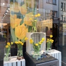 Shop window decorated with yellow flowers and a picture with a yellow flower....