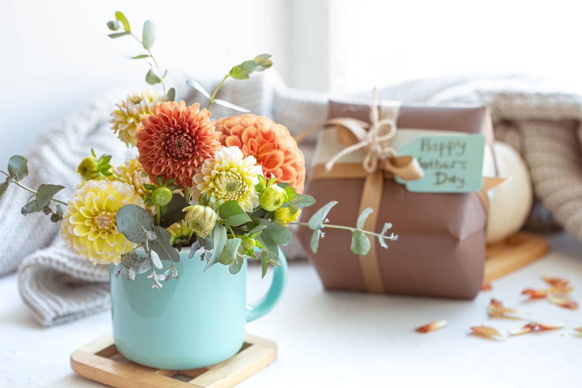 A bouquet of flowers and a gift in brown wrapping paper....