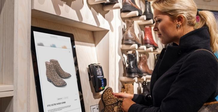 Woman using a touch display in a store; copyright: ELO Touch Solutions...