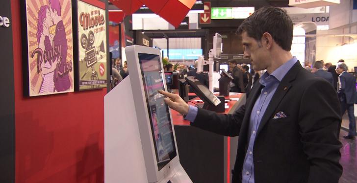 Man uses self service kiosk with touch screen; copyright: beta-web...