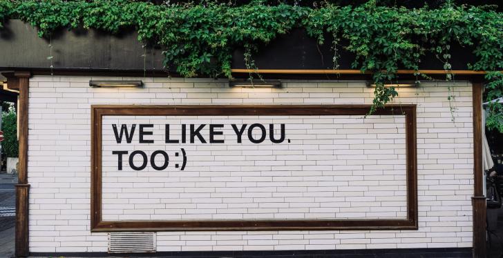 Sign on a wall with text we like you too; Copyright: Adam Jang/Unsplash...