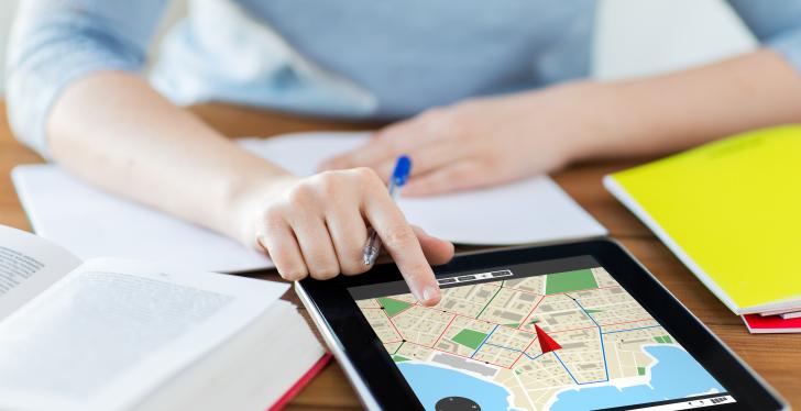 Hands on the desk operating a tablet