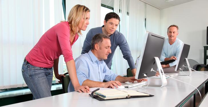 People watching a video on one desktop computer; copyright:...