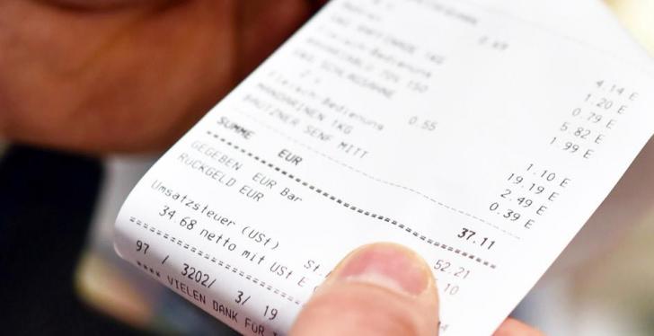 Two hands are holding a paper receipt from a retail store; copyright: APG...