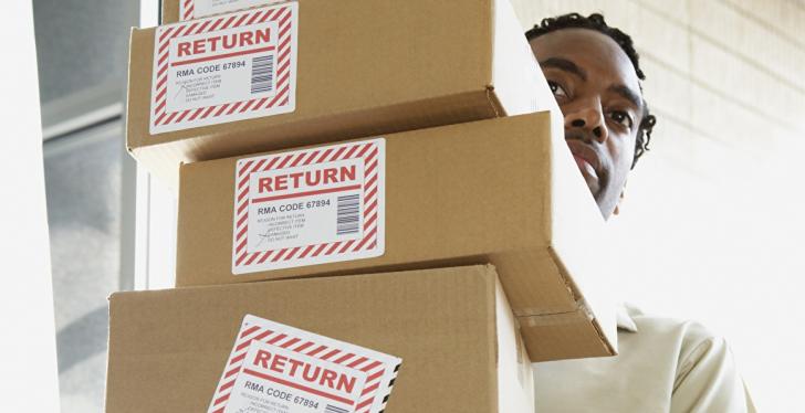 A man carries many packages with the inscription return...