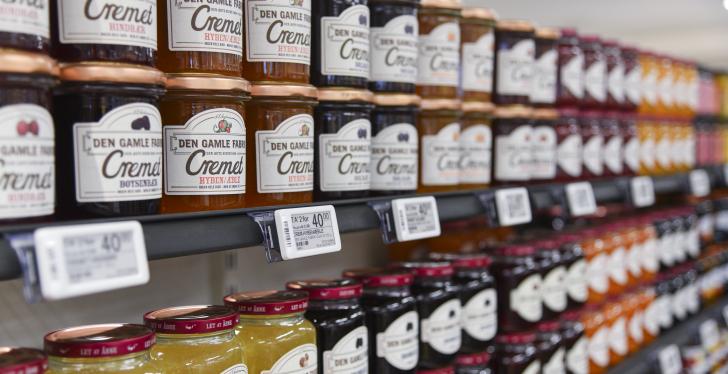 A row of shelves with jam jars, photographed from the side, with electronic...