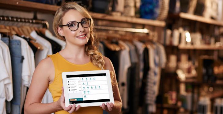 A blonde woman holding a tablet in her hand