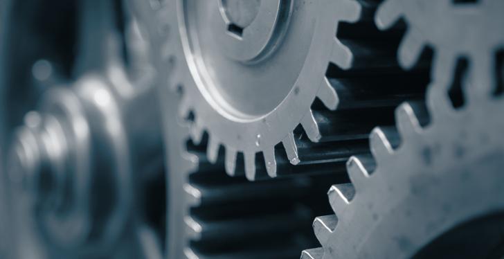 Close-up: Several steel gear wheels mesh together