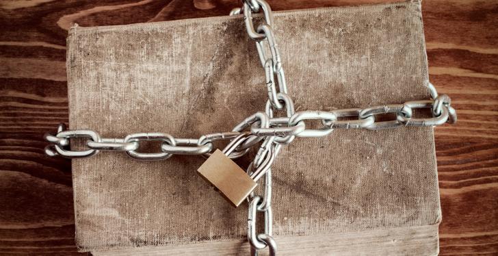 An old book locked with a chain and a padlock.