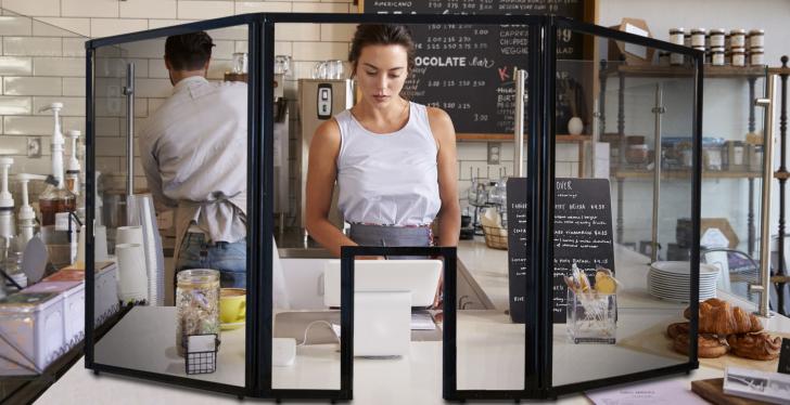 A young woman behind a counter in a gastronomical institution behind a...