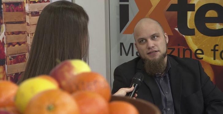 Oranges blurred in the foreground, in the background a man being interviewed...