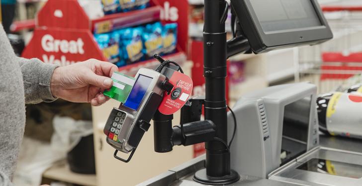 A man pays contactlessly at the supermarket checkout...