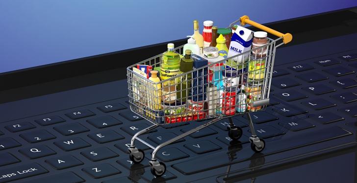 A full mini shopping cart is on the keyboard of a laptop...