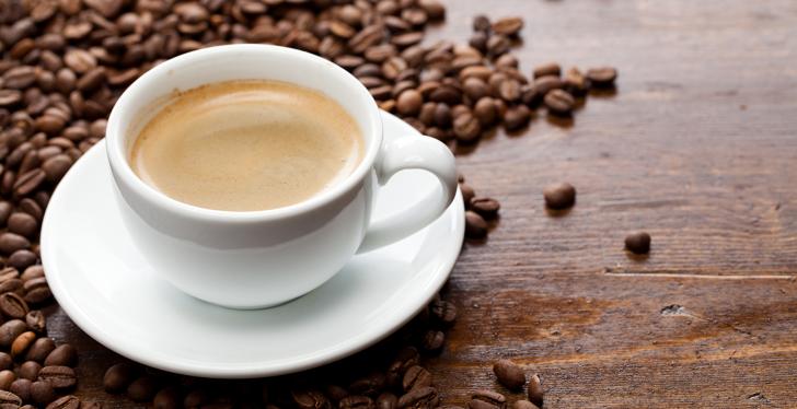 Coffee cup on wooden table with coffee beans