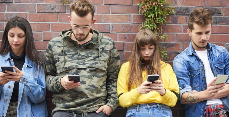 4 Menschen schauen auf ihre Smartphones