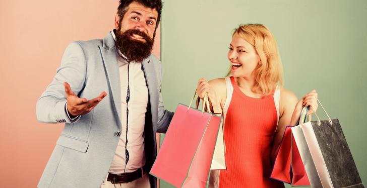 A man and a woman laughing with shopping bags