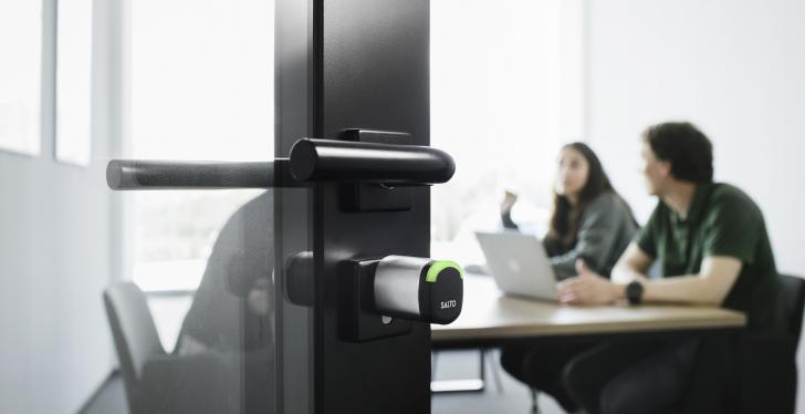 An open glass door at a meeting room with an electronic cylinder lock...