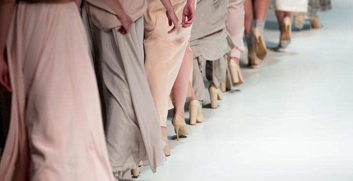 Models in dresses walking down a runway