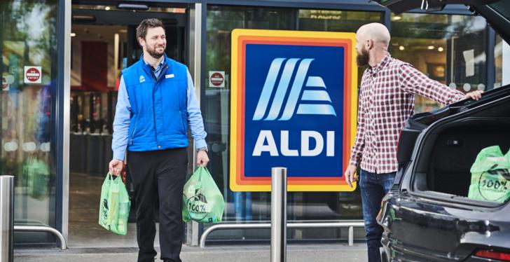 An Aldi employee carries a customers purchase to his car...