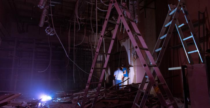 renovations in a dark room with ladders, cables and one light source...