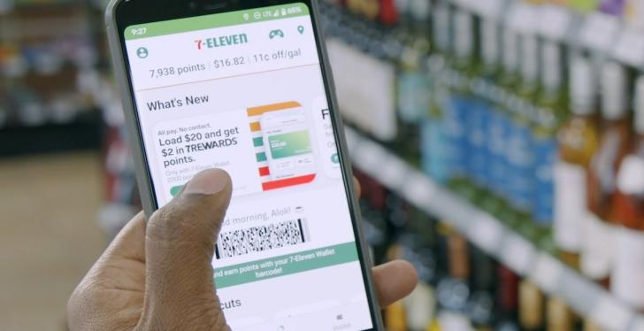 A hand holding a smartphone with an app in a store