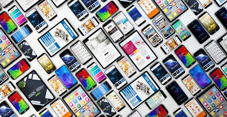 Many smartphones and tablet PCs lying on the ground in a grid pattern;...