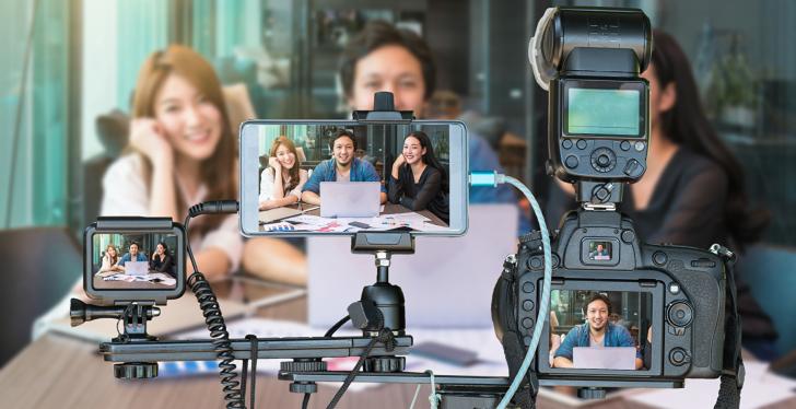 three persons in front of tripod with smartphones