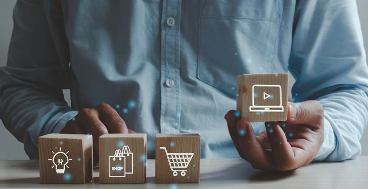 man sits in front of four small boxes with icons of a light bulb, shopping...
