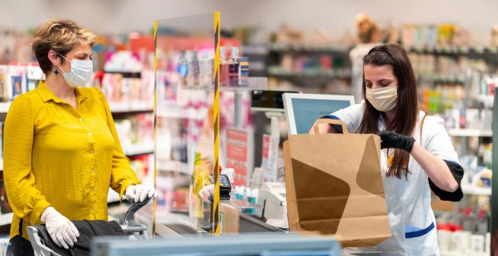 In a supermarket, a customer waits at the checkout line for the checkout to...