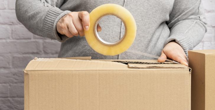 a woman wraps a package with tape