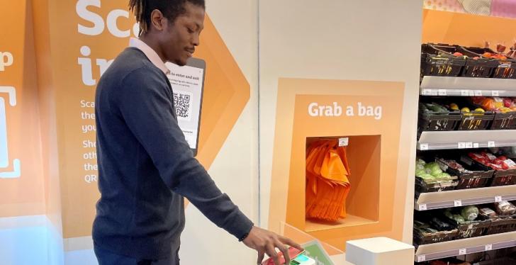 A man using his smartphone to check in at Sainsburys...