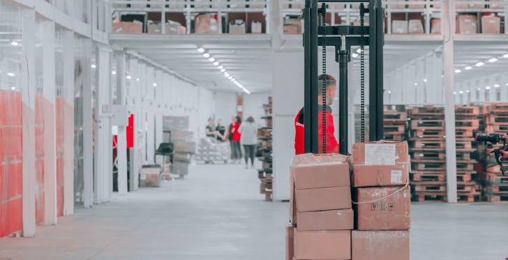 A man carrying packages on a forklift; Copyright: Jake Nebov/Unsplash...