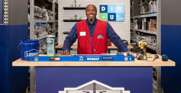 A home improvement store employee stands behind a counter and smiles for the...