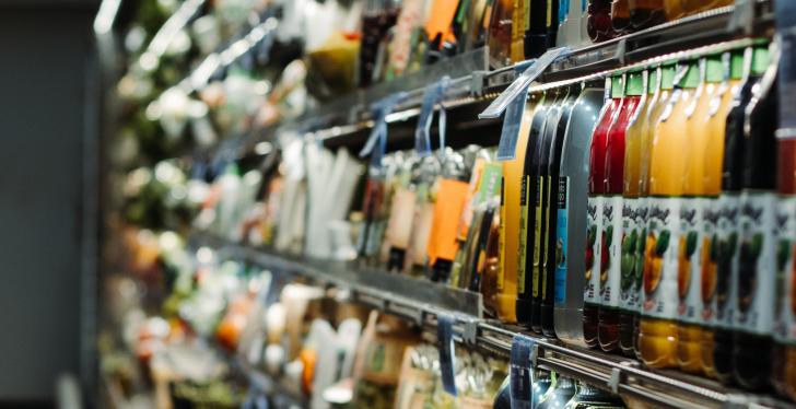 A refrigerated shelf with beverage bottles; copyright: Eduardo Soares/Unsplash...