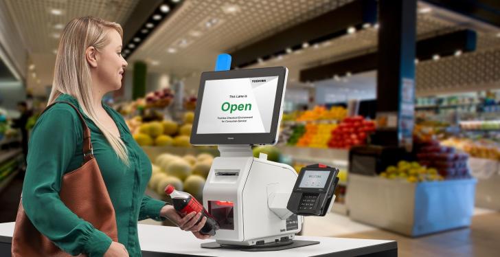 A person uses a self-checkout cash register