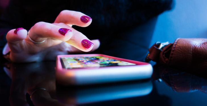 A hand with painted nails types on a smartphone; copyright: Rob Hampson/Unsplash...