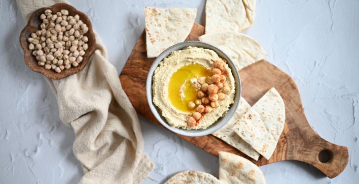 Pita chunks and dip on a wooden board; copyright: Pexels/Eat Kubba....