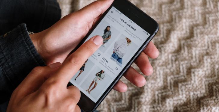 A person is using a smartphone to shop clothes online...