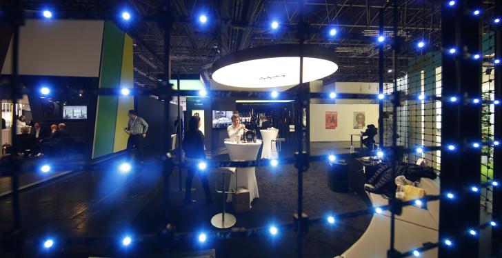 Atmospherically illuminated booth at the EuroShop fair behind a black grid with...