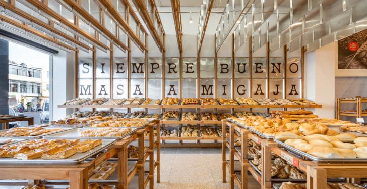 A counter display in a bakery with many different breads and buns...