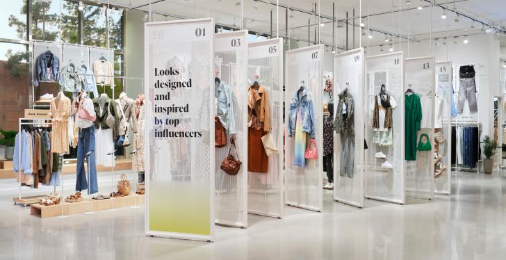 Different outfits on clothes rails in a fashion store...