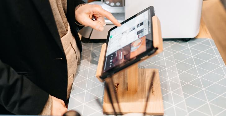 A person uses a tablet for checkout