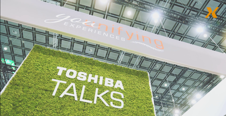 Image: Wall at a trade fair stand with green moss and the words Toshiba Talks....
