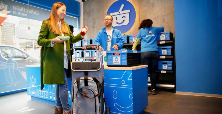 A customer puts goods into a shopping bag at a checkout counter...