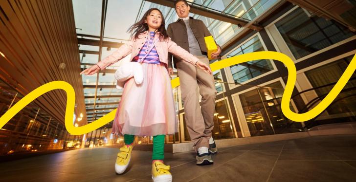 A child and an adult walk through a shopping centre...