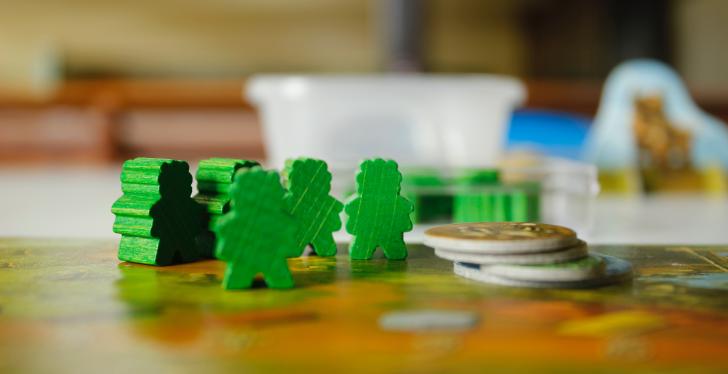 Green figures and coins on a game board