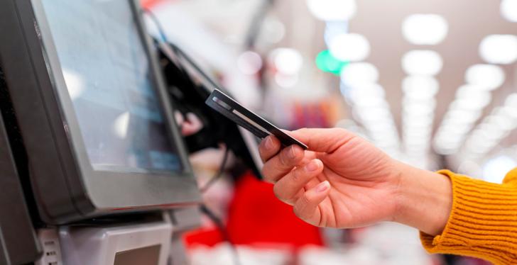 A hand inserts a check card into a reader