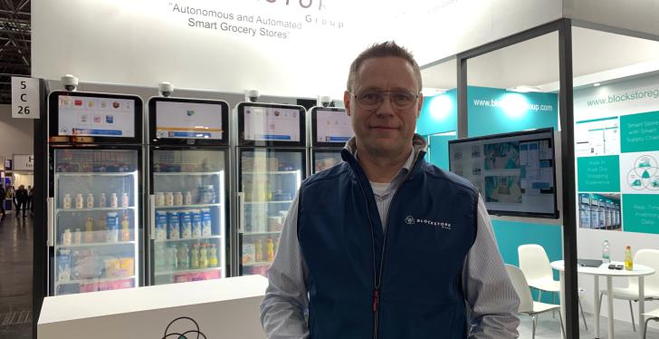 Man with blue waistcoat in front of several refrigerators...