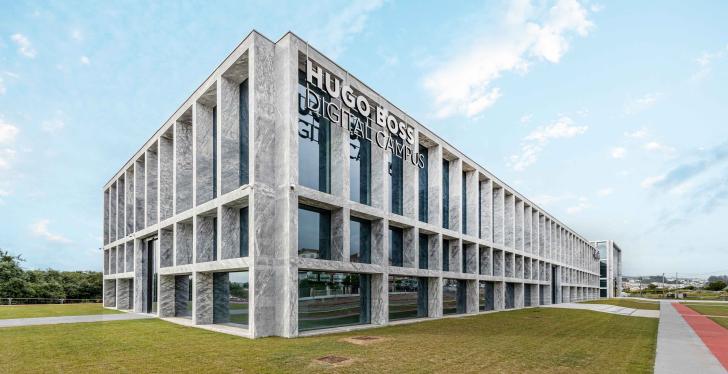 Exterior view of a large building with the sign Hugo Boss Digital Campus...